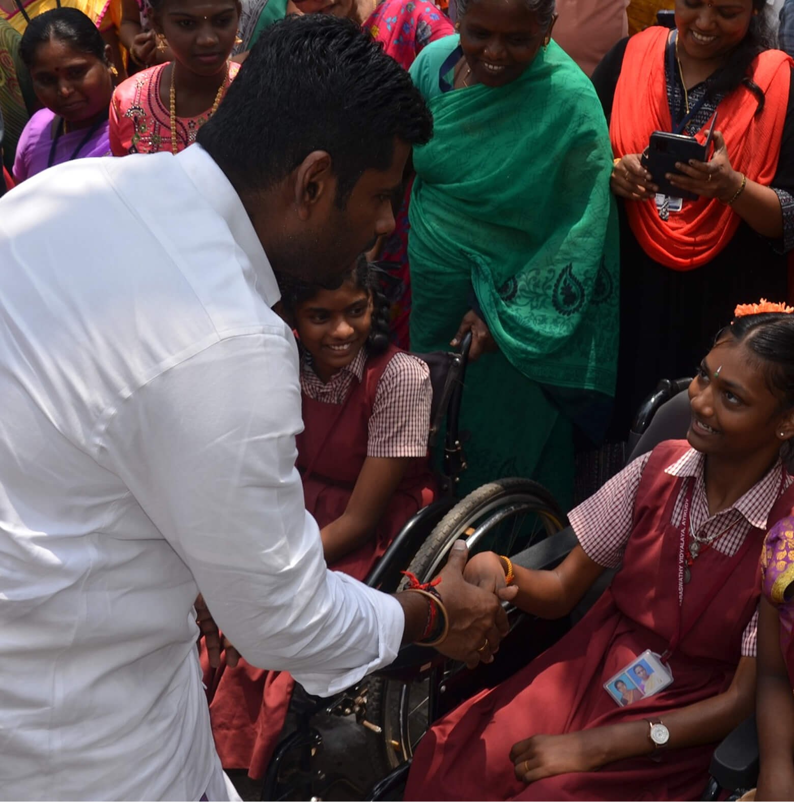 Chief Servant K. Annamalai greeting a young student in the community